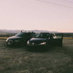 two black vehicles parked beside green grass