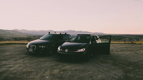 two black vehicles parked beside green grass