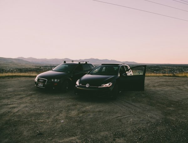 two black vehicles parked beside green grass