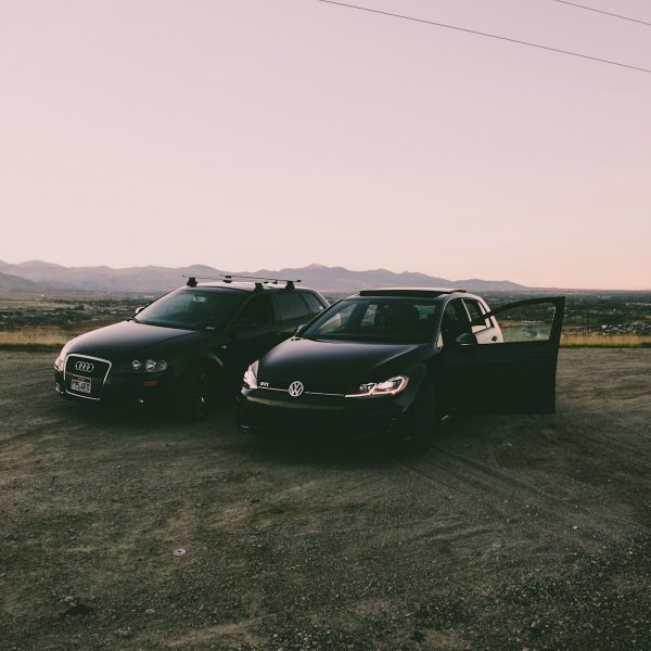 two black vehicles parked beside green grass