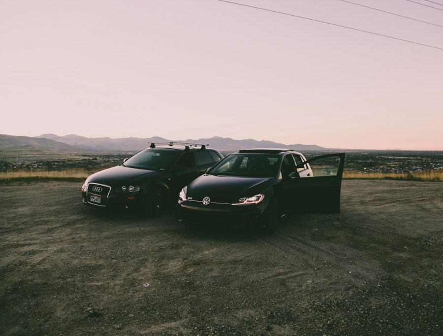 two black vehicles parked beside green grass